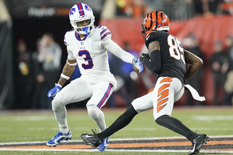 Two men in football uniforms on a field.