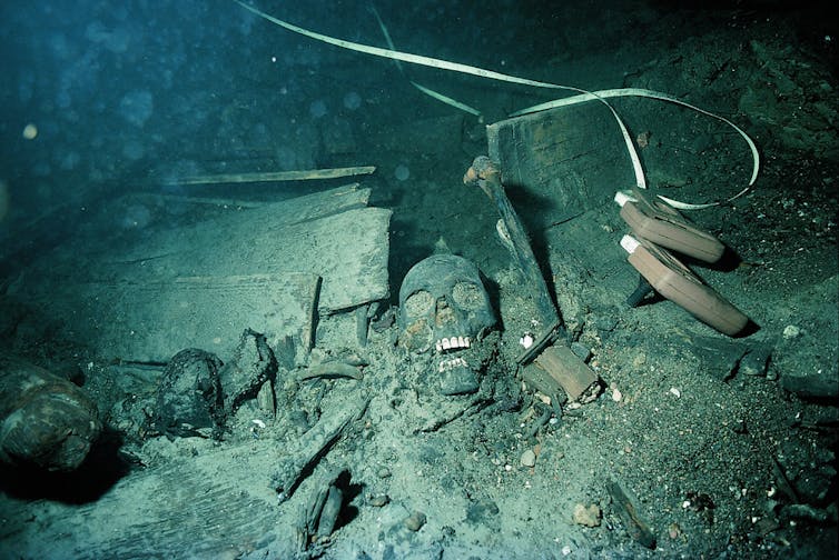 Skull in remains of boat underwater.