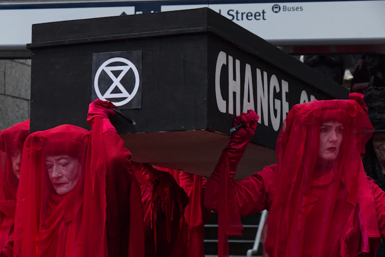 women in red hold XR coffin