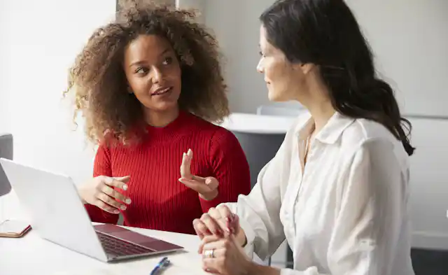 Two people seen in discussion in an office.