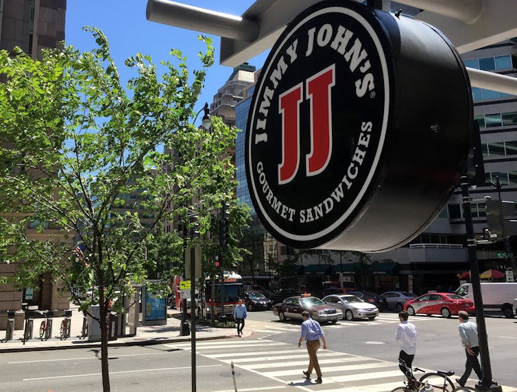 Jimmy John's sign outside a retail store in front of a street and a crosswalk