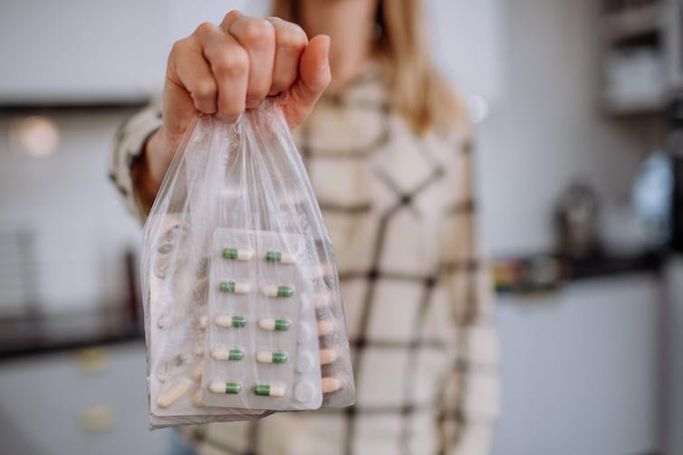Person holding a bag of pills