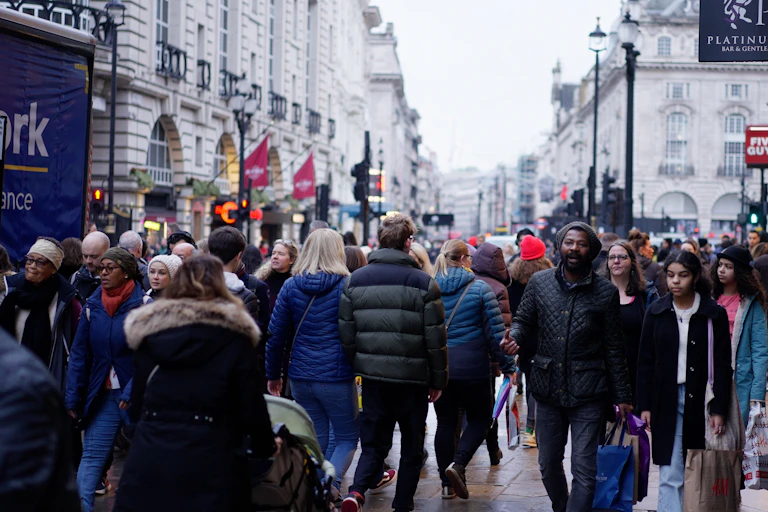 People in coats in a crowded street.