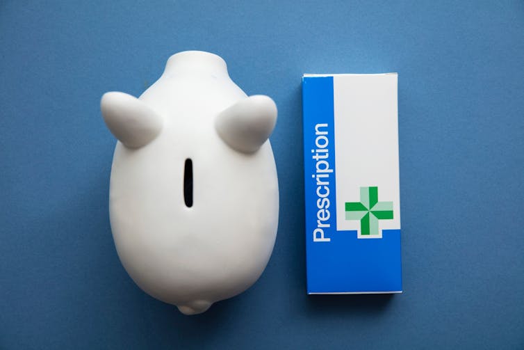 A piggy bank seen from above beside a prescription box