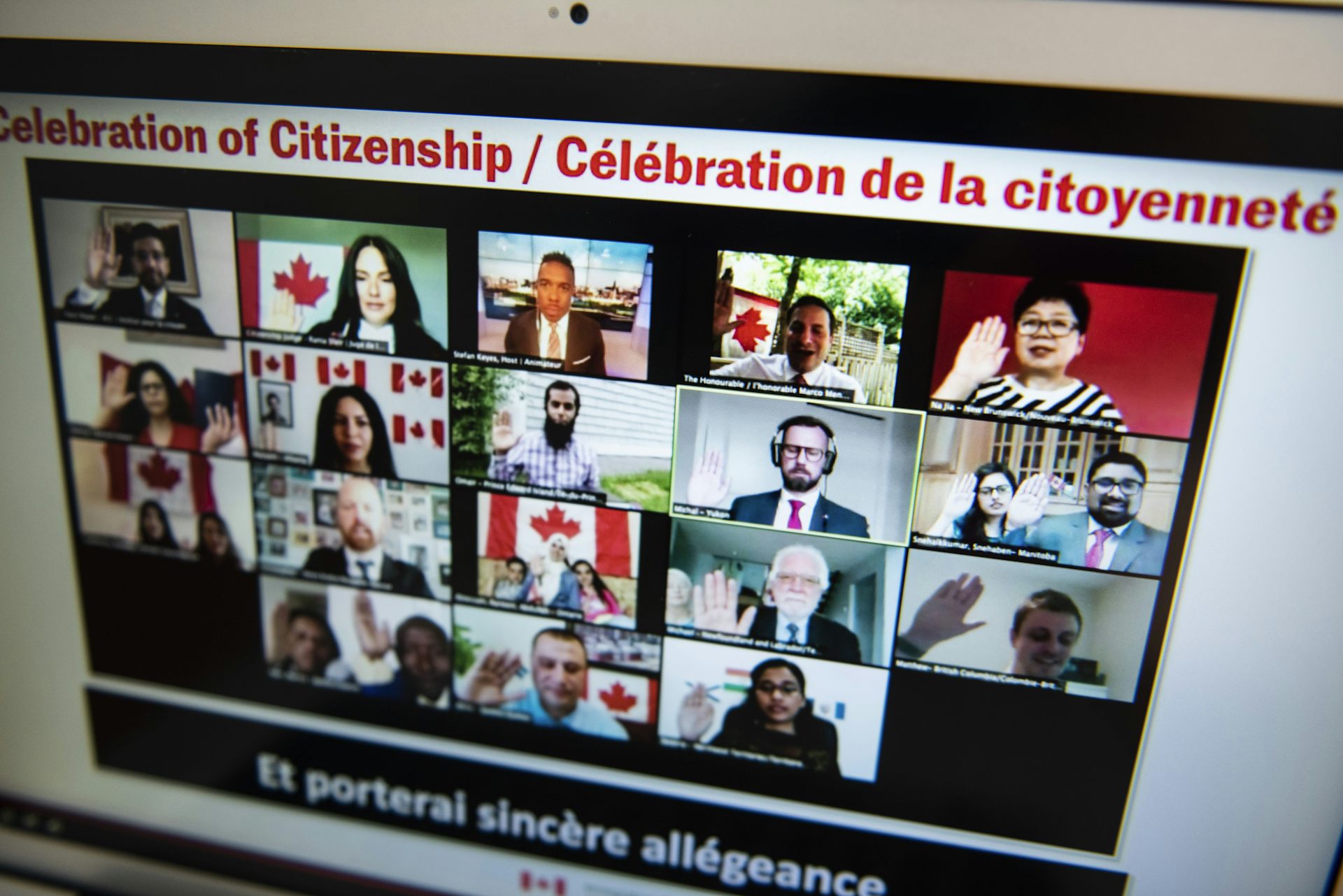 People take the oath of Canadian citizenship in a virtual ceremony seen on a computer screen.