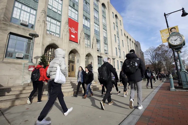 Students seen walking across a campus.