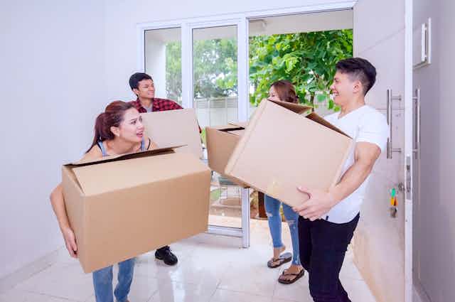 Students struggling to carry boxes as they move into new accommodation