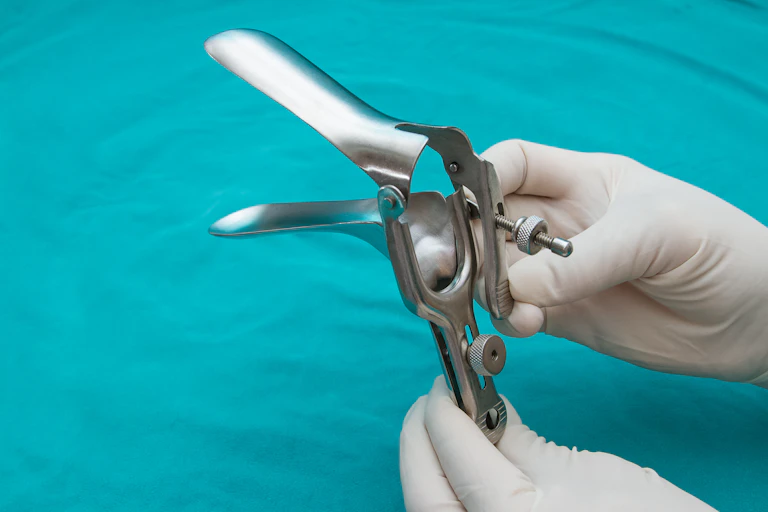 Doctor holds a disposable speculum in their hand.