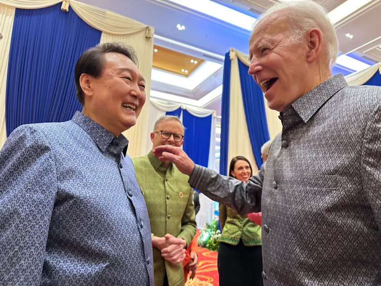 South Korean president, Yoon Suk-yeol, and US president, Joe Biden, wearing colourful shirts and laughing together.