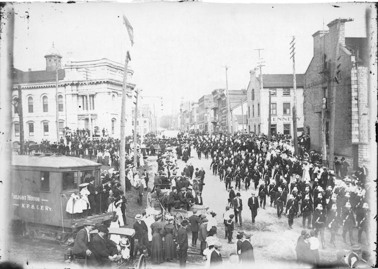 Crowd of people seen in a street for a parade.