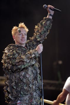 Johnny Rotten on stage in military camouflage.