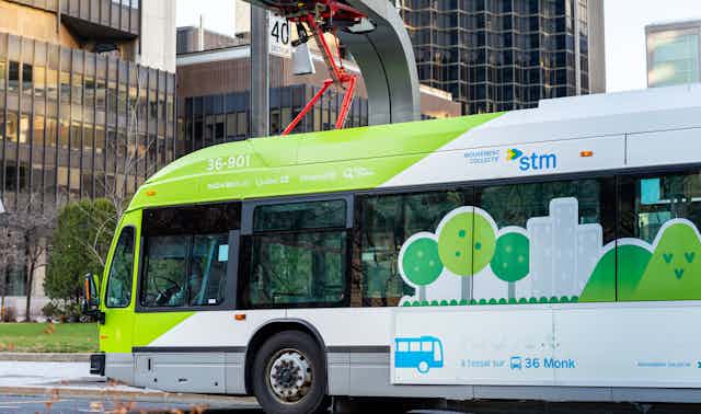 An electric transit bus plugged into a charging station