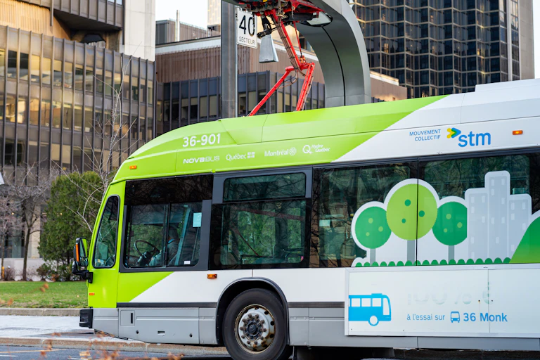 An electric transit bus plugged into a charging station