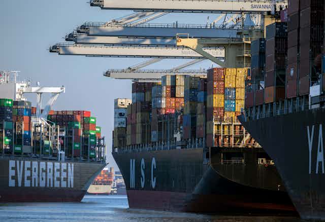 massive container ships with colorful containers  approach a port
