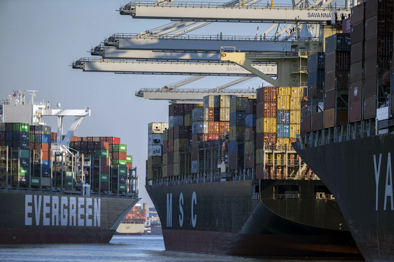massive container ships with colorful containers approach a port
