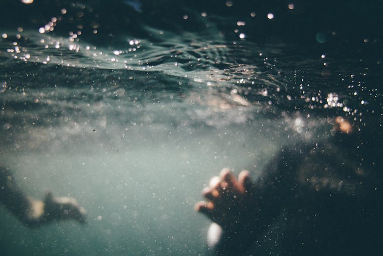 young person underwater swimming