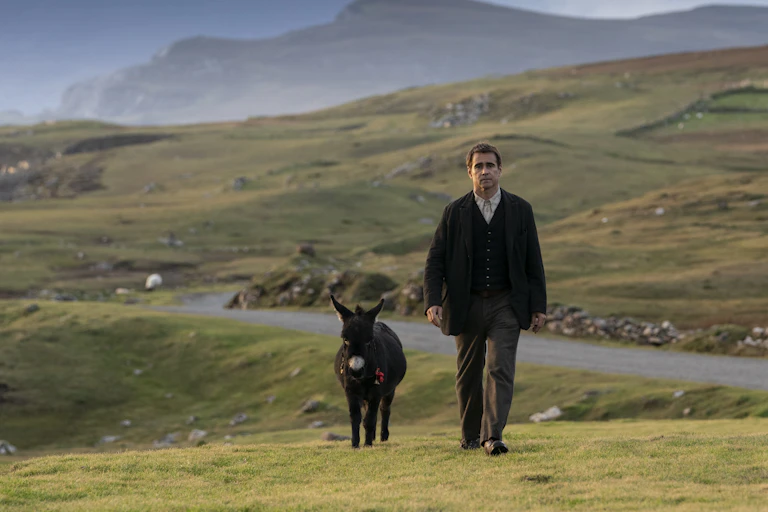 Pádraic (Colin Farrell) strides through dramatic Irish countryside with his companion, Jenny the little donkey.