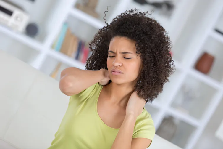 Mujer sujetándose el cuello dolorido