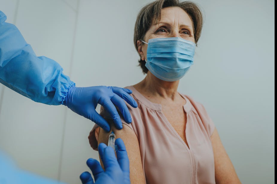 A woman receives a vaccination.