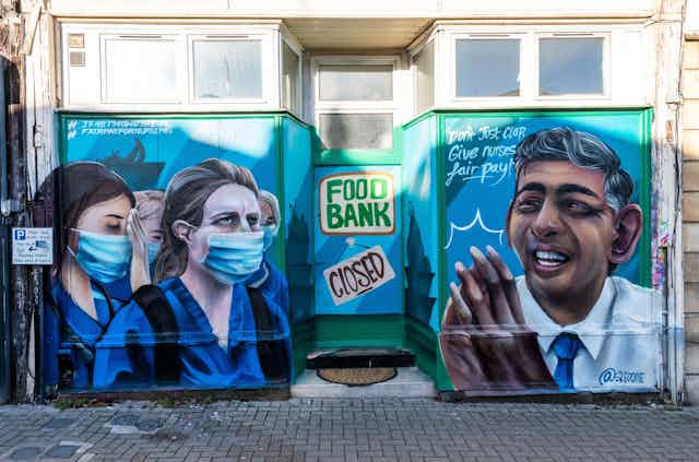 Graffiti depicts exhausted nurses, a closed food bank and a smiling Rishi Sunak under the words 'Don't just clap, give nurses fair pay!'