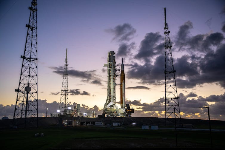 A rocket sitting on a launchpad in morning light.