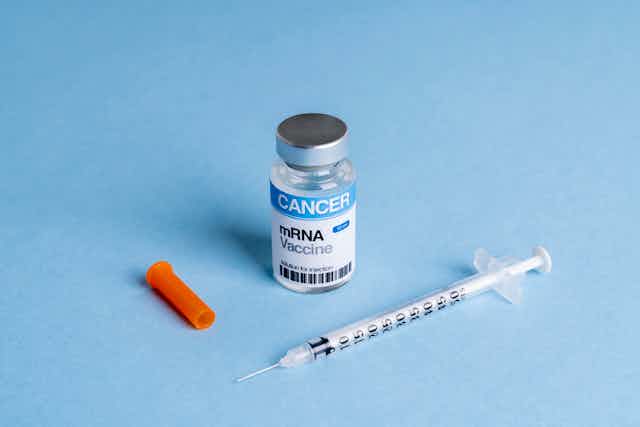 Mock mRNA cancer vaccine vial with syringe against blue background