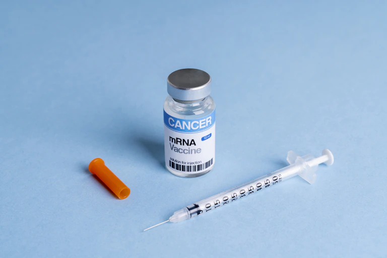 Mock mRNA cancer vaccine vial with syringe against blue background