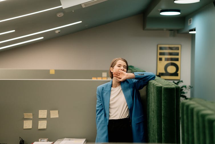 A woman looks tired at work.