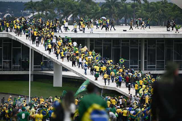 Supporters of former President Jair Bolsonaro storm the National Congress, many wearing the famous yellow Brazil national football jersey