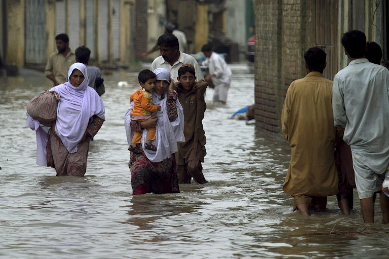 people wade through flooded streets