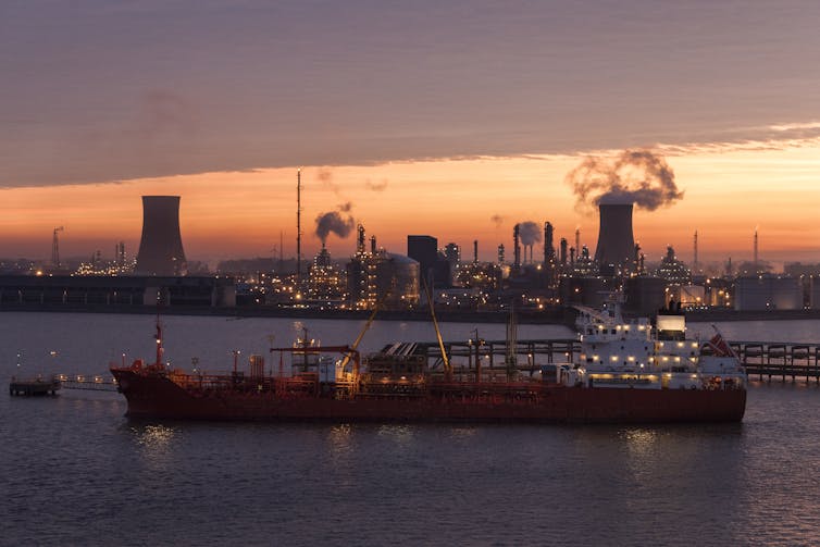 A ship in front of the industrial skyline of the Humber Estuary at dawn.