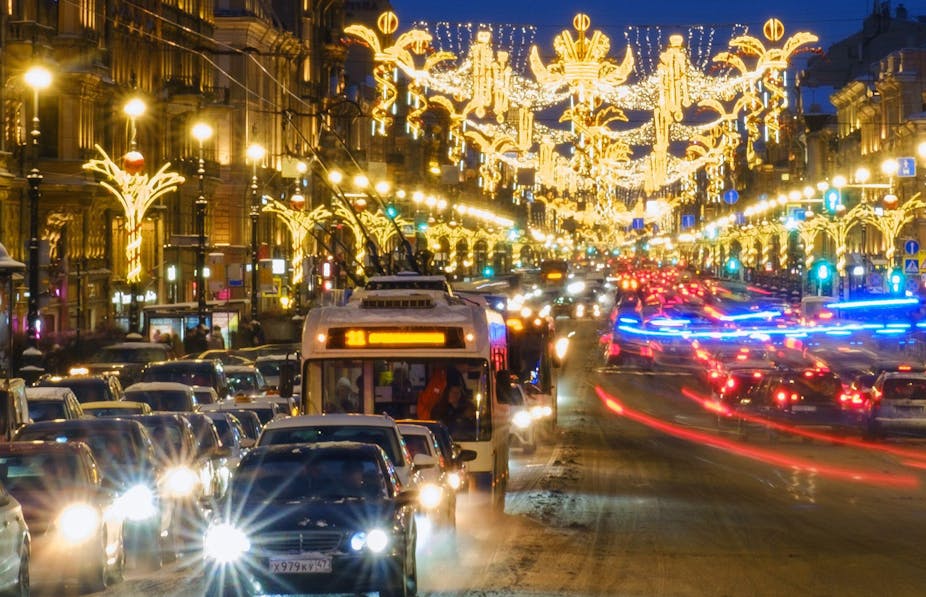 Cars and buses on the streets of St Petersburg which are lit up with Christmas decorations
