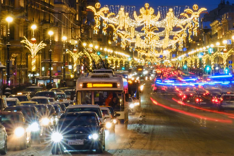 Cars and buses on the streets of St Petersburg which are lit up with Christmas decorations
