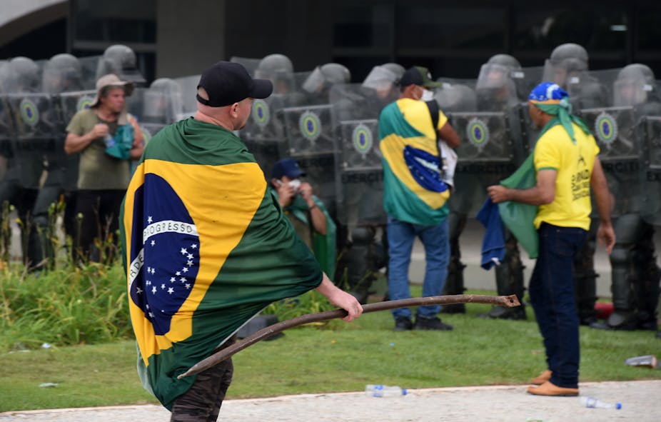 Partisans de Bolsonaro face à des forces de police anti-émeute