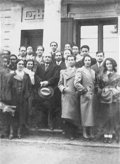 Un grupo de hombres y mujeres posan en la calle.