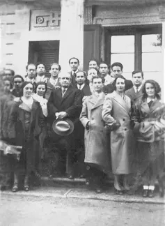 Un grupo de hombres y mujeres posan en la calle.