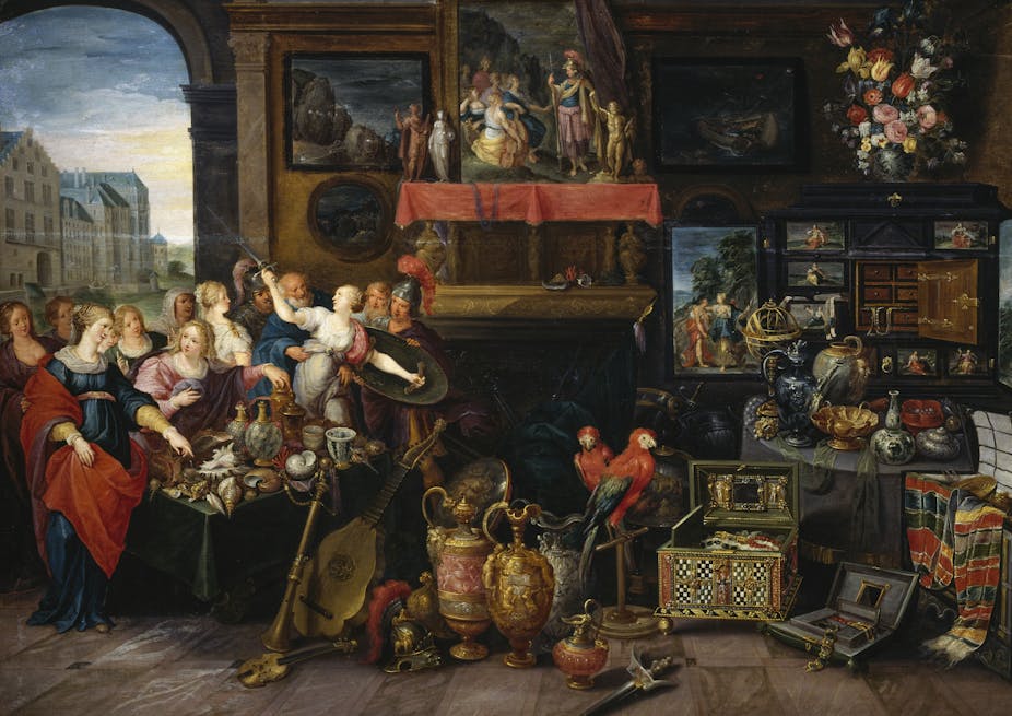 An oil painting showing men and women dressed in colorful attire standing on one side of a room full of art objects.