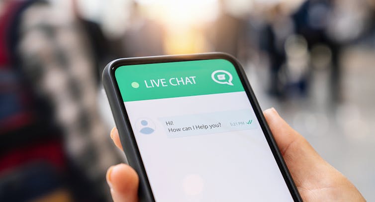A smartphone displaying a chat screen with a message bubble that reads: Hi how can I help?