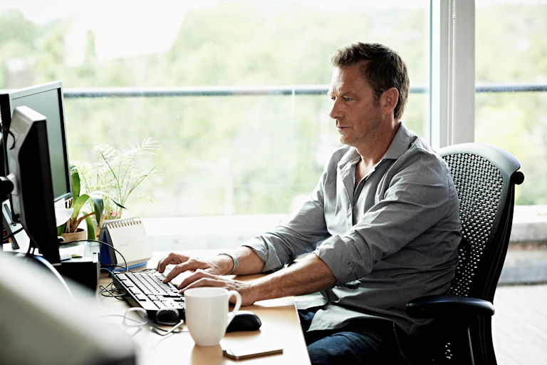 A man sitting at his desk working on his computer.