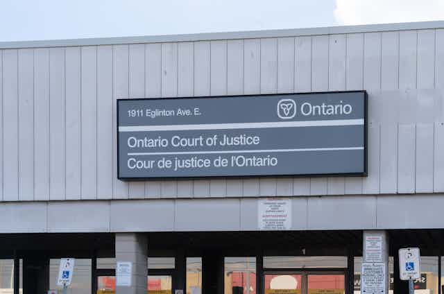 close up of grey building with plaque ONTARIO COURT OF JUSTICE