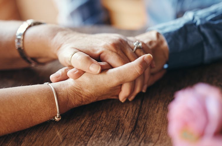 Two people hold hands.