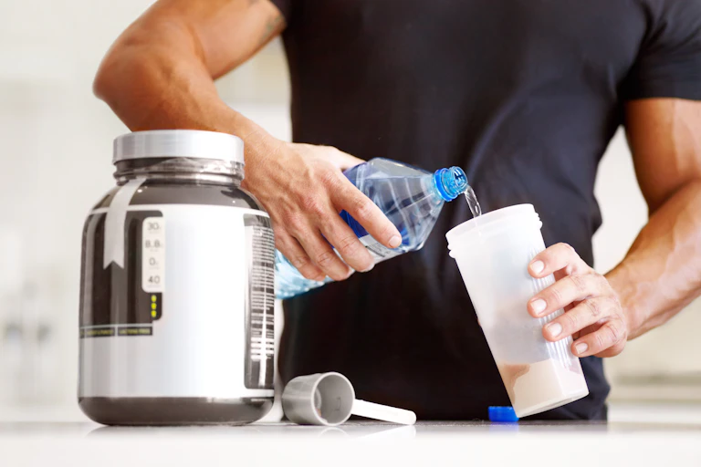 A man mixes water with the creatine powder in his cup.