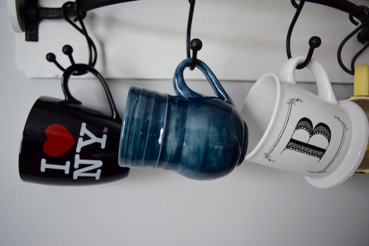 Una serie de tazas colgadas, incluyendo una con el logo I love NY.