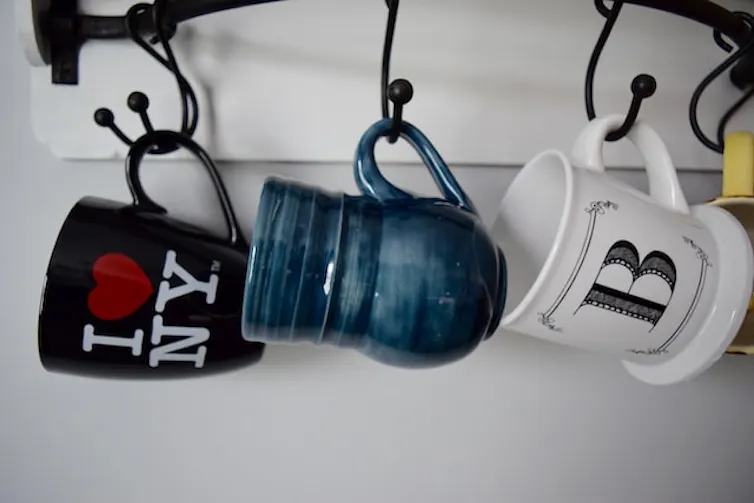 Una serie de tazas colgadas, incluyendo una con el logo I love NY.