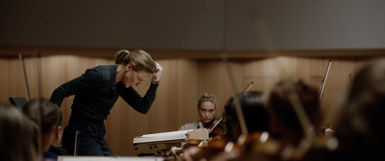 A woman conducts an orchestra