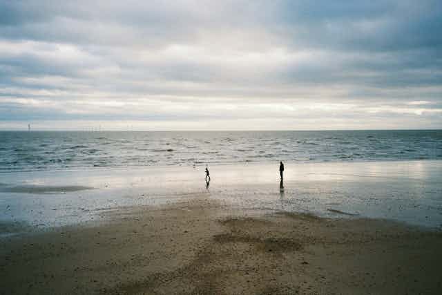 An adult and child at a winter shore