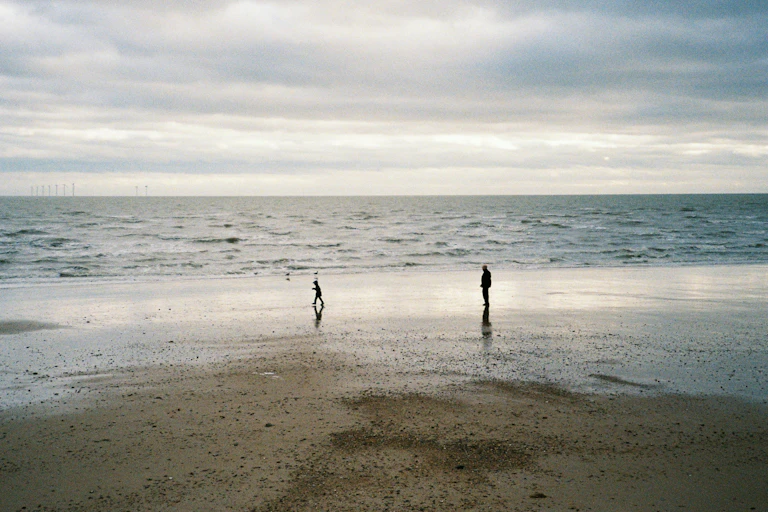 An adult and child at a winter shore