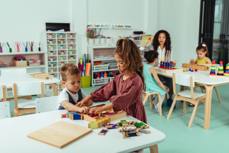 Children seen working at a table in a classroom.