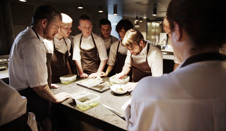 Chefs looking at a dish.