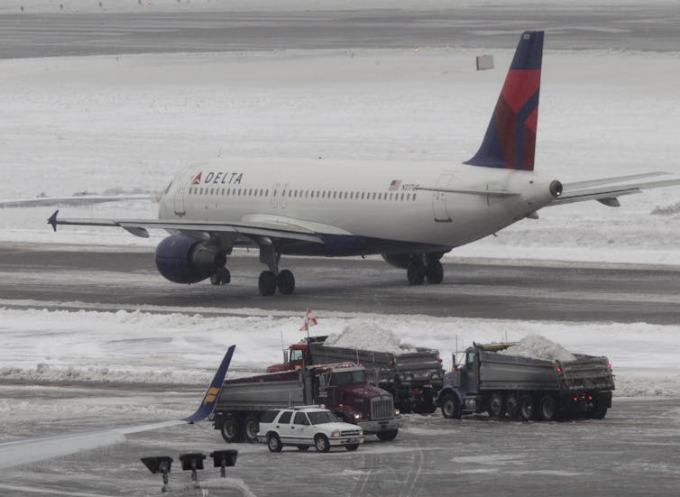 A plane taxiing on a snowy runway.